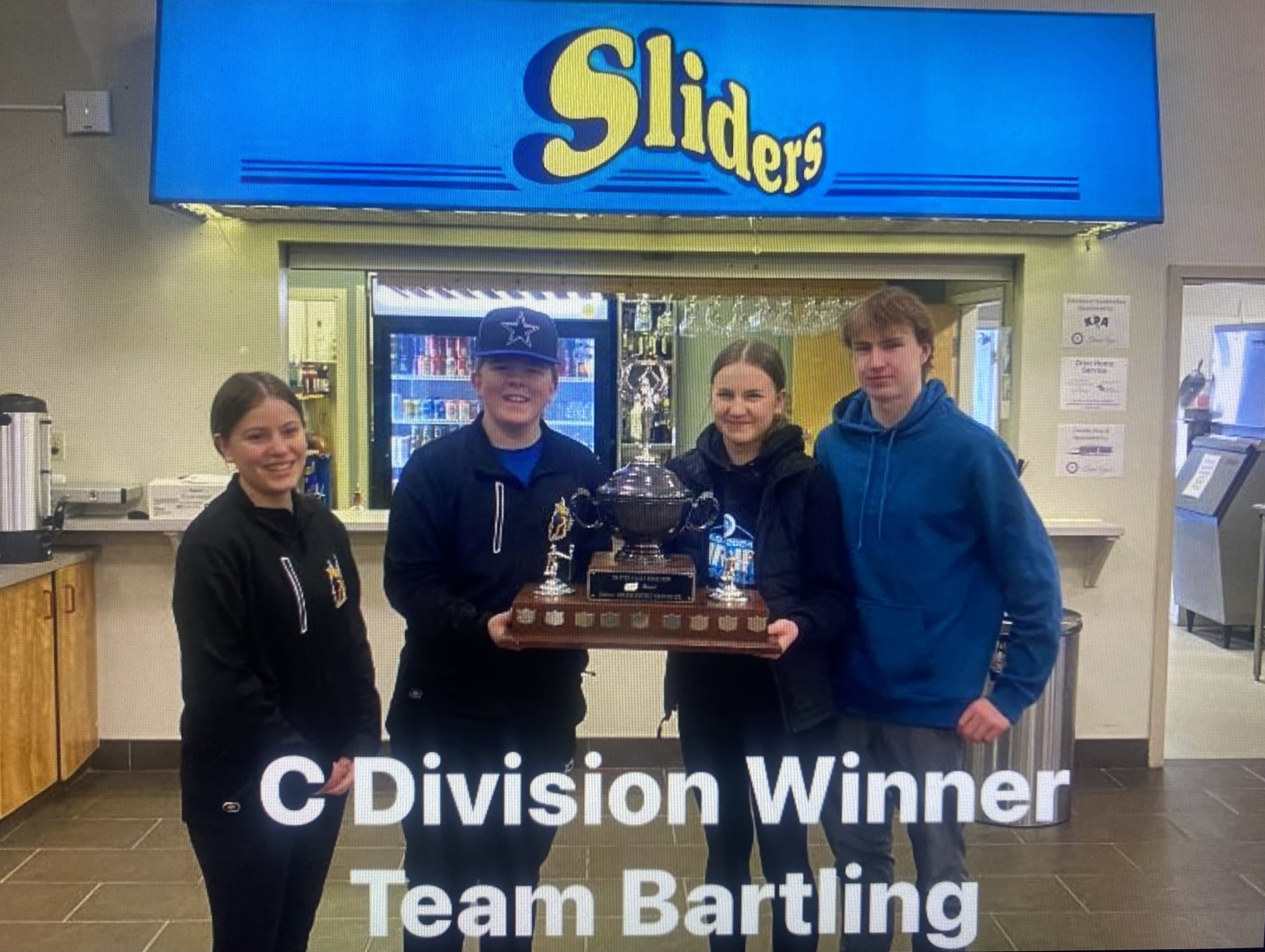 Team Bartling standing together holding their division trophy